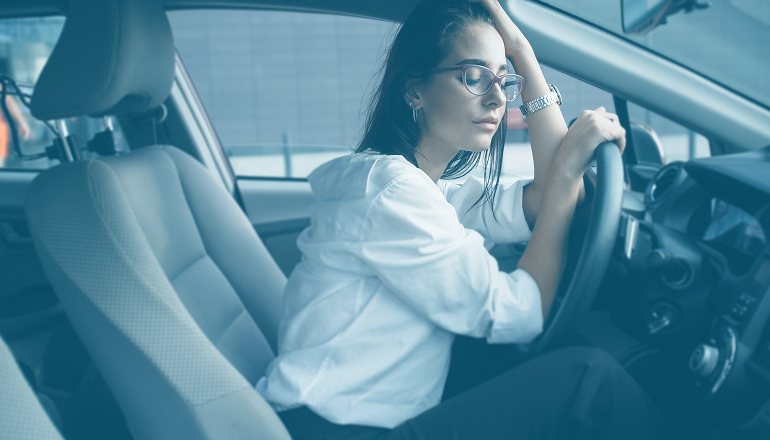 mujer en el coche apoyada en el volante por trastorno de estrés postraumático tras un accidente de tráfico